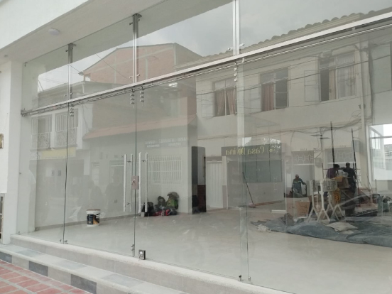 Frente de vidrio templado con puertas batientes instalado en un local comercial